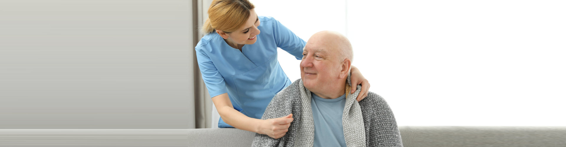 caregiver checking her senior patient on couch